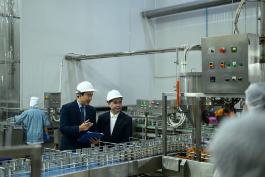 Two factory executives discussing operations inside a food manufacturing facility.