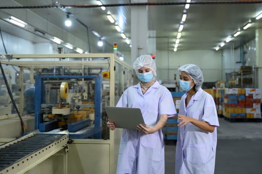 Food factory staff reviewing production data in a food packaging facility.