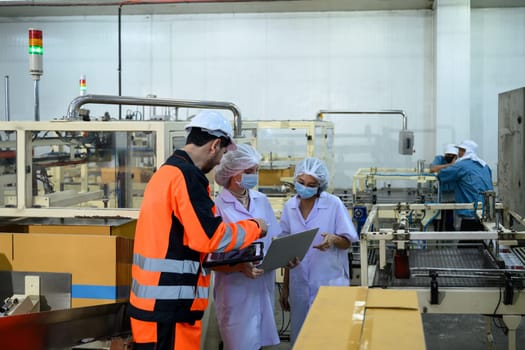 Engineers and quality control staff inspecting production process in an industrial food facility.