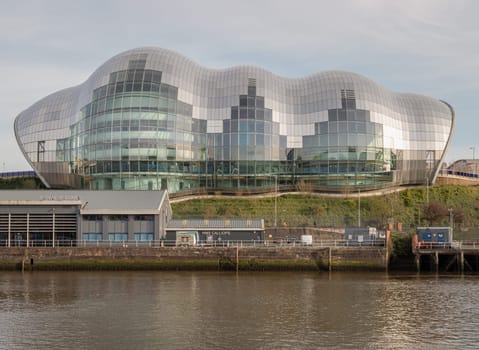 Newcastle, UK - Apr 11, 2025 - Architecture exterior view of The Glasshouse International Centre for Music or Sage Gateshead by the River Tyne. Modernist futuristic glass building, A concert venue and cultural centre in the city of Newcastle upon Tyne in Northumberland, use it as your Wallpaper, Poster and Space for text, Selective focus.