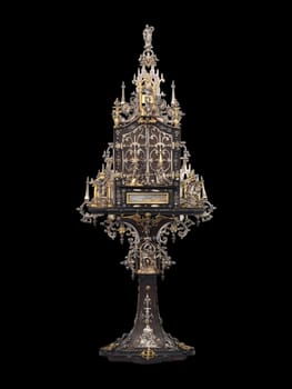 this detailed antique shrine showcases intricate gold and silver metalwork, embodying a gothic and historical aesthetic. the ornate religious artifact rests on an elegant pedestal, highlighting its craftsmanship and sacred significance. perfect for collectors of religious art and historical artifacts.