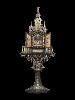 this detailed antique shrine showcases intricate gold and silver metalwork, embodying a gothic and historical aesthetic. the ornate religious artifact rests on an elegant pedestal, highlighting its craftsmanship and sacred significance. perfect for collectors of religious art and historical artifacts.