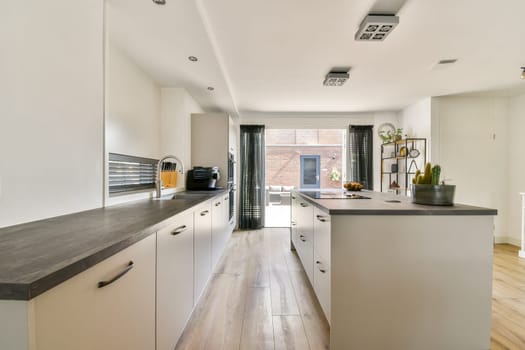 A stylish modern kitchen featuring sleek cabinets, wooden countertops, and abundant natural light, creating a warm and inviting atmosphere.