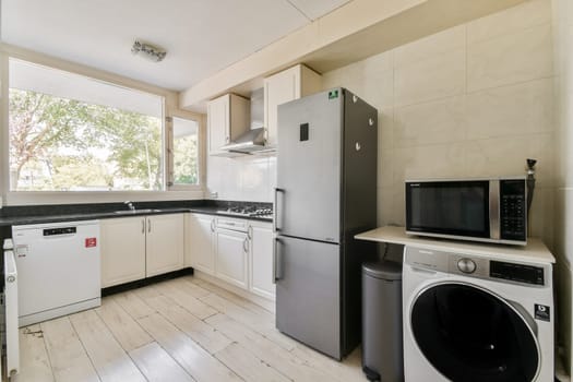 A stylish and functional modern kitchen featuring sleek appliances, ample storage, and an open view to nature, creating a bright and inviting atmosphere.
