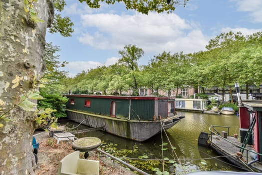 A peaceful scene showcasing a houseboat moored on a tranquil waterway, bordered by vibrant trees and serene nature. Perfect for relaxation and reflection.