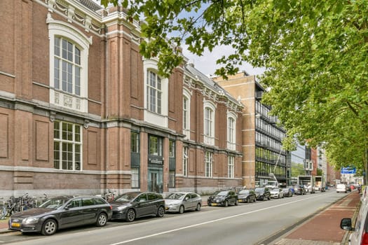 A scenic view showcasing a blend of historic and modern architecture, with cars parked along a tree-lined street in an urban environment.