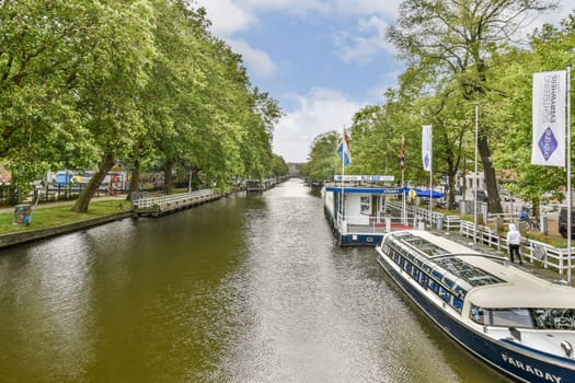 Serene canal view lined with tall trees and a boat dock, set against a bright sky. Ideal for showcasing tranquil water landscapes.