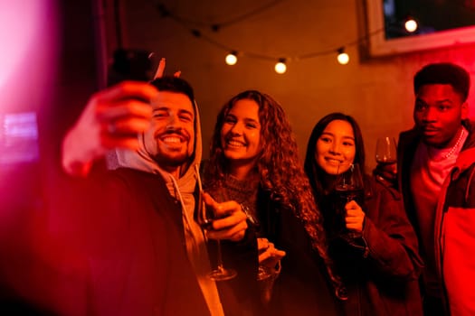 Friends gather in a warm atmosphere of a trendy bar, smiling as they take selfies together while enjoying their drinks. The ambiance features festive lighting and laughter.