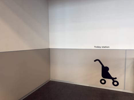 Wall signage showing trolley station in public space. Modern interior with minimalist design used to indicate stroller parking zone in urban infrastructure