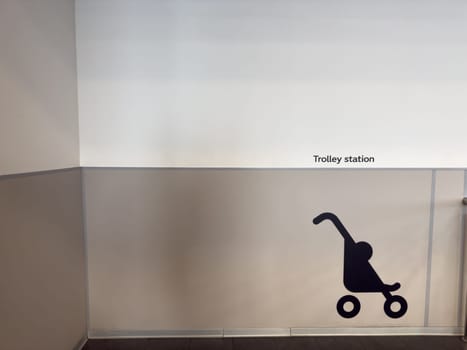 Wall marking indicating stroller parking zone in public interior. Urban signage for parents and accessibility in commercial infrastructure. Clean design for modern navigation and service clarity