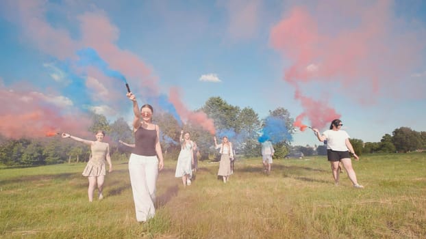 Group of teenagers walking in a field, holding colored smoke bombs, enjoying summer break and celebrating graduation