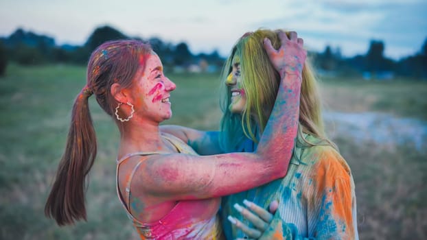 Two joyful school friends embracing, adorned in colorful holi powder paint, commemorating friendship and happiness at the vibrant festival
