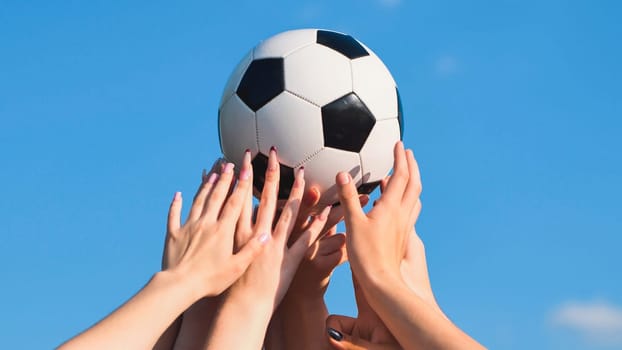 Friends from school celebrating victory with a soccer ball under a clear blue sky, symbolizing teamwork and success