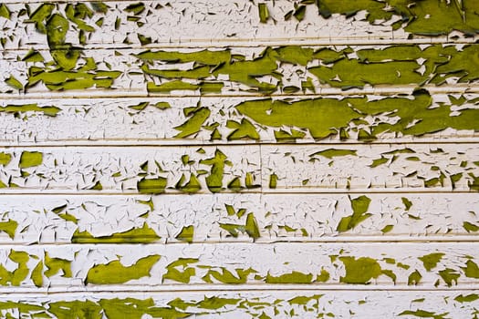 Peeling green paint on white wooden planks creates a textured, weathered background, ideal for grunge or vintage projects