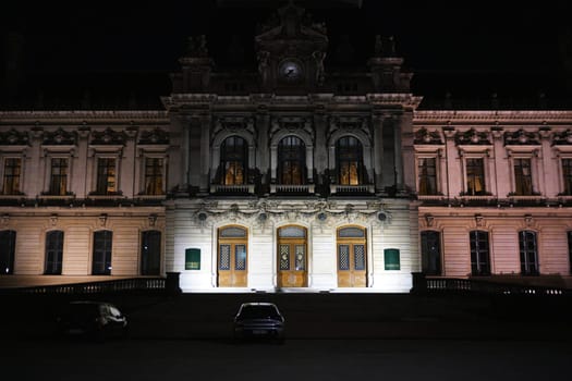 Symmetrical night view of the Prefecture of Rhone in Lyon, France, with ornate neoclassical architecture and soft exterior lighting.