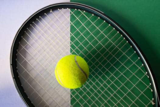 Racket and ball set on green and white background, flat lay. Isolated. Top view.Copy space.Promotional background for tennis sport. Real horizontal picture