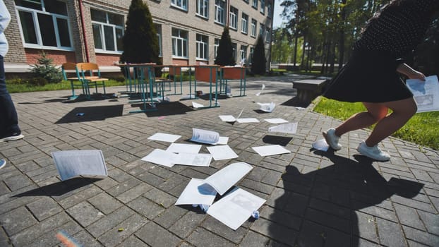 School is out, and students are throwing exam papers in the air, celebrating the end of the school year