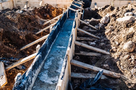 Strip foundation being built for new house concrete pouring with wooden formwork