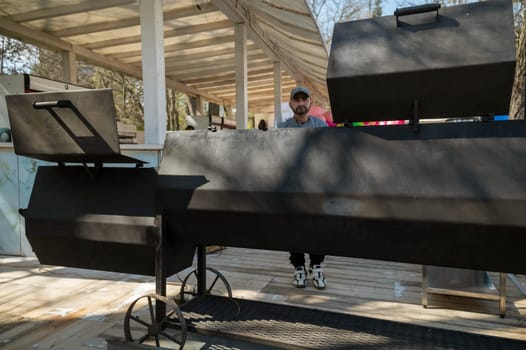 Odessa, Ukraine - April 05, 2025 : city street food festival. male cook who cooks barbecue. huge barbecue setup.