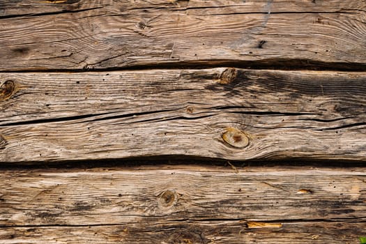Horizontal wooden planks forming a textured surface with cracks and knots