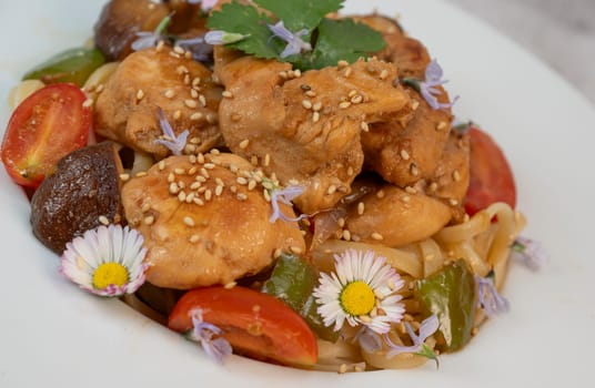 A flavorful blend of chicken, linguine, shiitake mushrooms, bell peppers, and fresh garden flowers offers a vibrant and appetizing meal. Ideal for a cozy dinner or gathering.