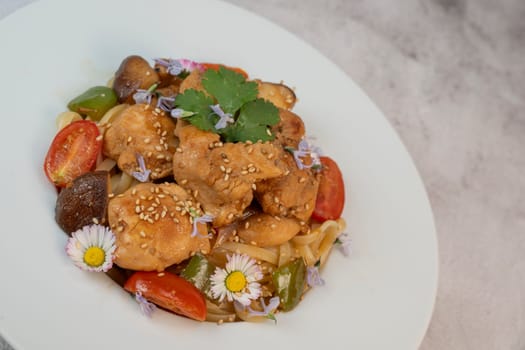 A flavorful blend of chicken, linguine, shiitake mushrooms, bell peppers, and fresh garden flowers offers a vibrant and appetizing meal. Ideal for a cozy dinner or gathering.
