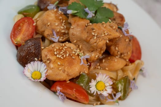A flavorful blend of chicken, linguine, shiitake mushrooms, bell peppers, and fresh garden flowers offers a vibrant and appetizing meal. Ideal for a cozy dinner or gathering.