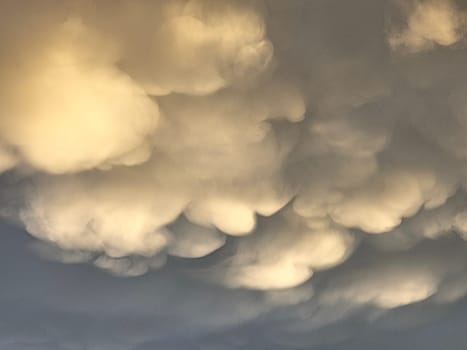 Storm clouds on sunset. Light in the dark and dramatic storm clouds. Background of storm clouds before a thunderstorm. Mammatus clouds. High quality photo
