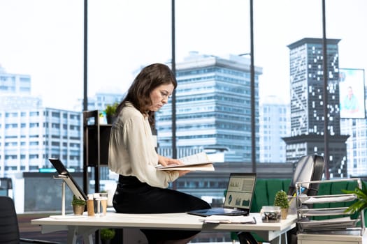 Empowered female CEO working in her high end corporate office, focusing on career development and maintaining a productive goal oriented work environment. Strategic thinking for growth.