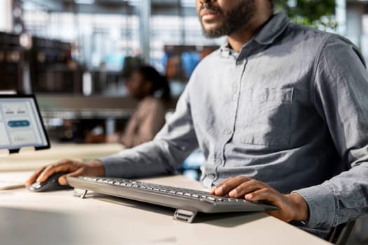 Businessman analyzing performance metrics on his computer at the workplace, office life. Engaged in strategic planning, he reviews data to support company objectives for successful outcomes.