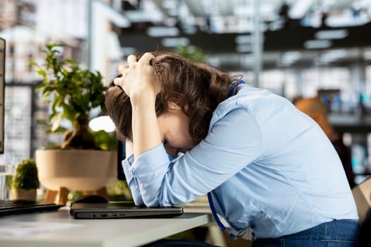 General director sits at her workstation frustrated and overwhelmed by the tasks deadline, business operations challenges. Woman dealing with fatigue after experiencing pressure at the office.