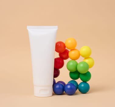White plastic tube for cosmetics on a beige background. Template for branding, advertising and product promotion