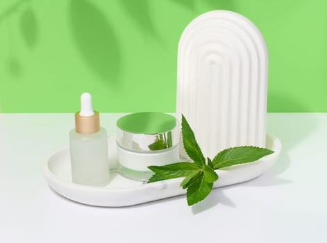Jar, white glass bottle with pipette and mint leaves, container for aromatic oils and cosmetics
