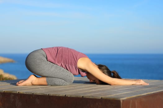 Profile of a woman doing yoga on the beach