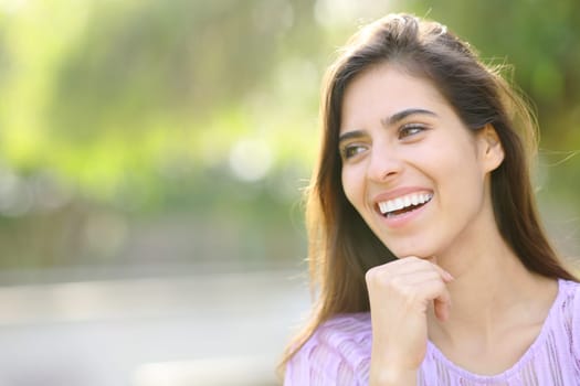 Happy woman with perfect smile looking away in a park