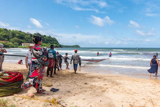 Galle, Sri Lanka - September 14 2024; Two men coming in through small surf in traditional fishing boat or 
oruwa at South Sri Lankan beach.