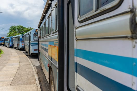 Galle Sri Lanka - September 14 2024; Curving line of parked buses beside footpath in city.