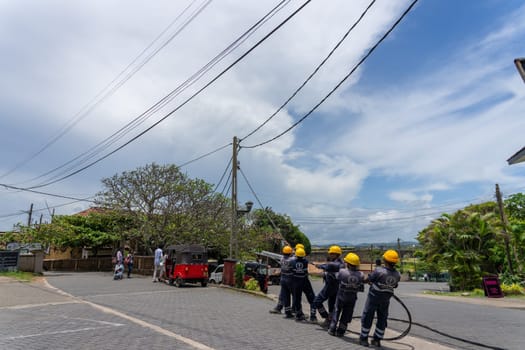 Workers erecting power lines in third world country of Sri Lanka.