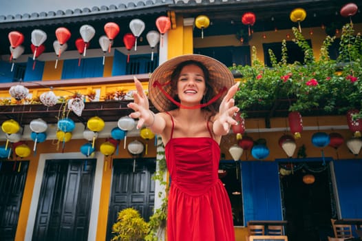 happy beautiful woman tourist in Vietnamese hat on street in old town in Hoi An city in Vietnam in Asia