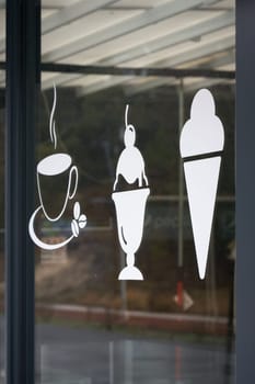 Symbols on the shop window indicating a café in the center of Swinoujscie in Poland