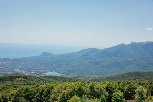Beautiful landscape on green forest mountains and blue sky from the top of the cliff