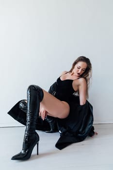 Fashionable slim woman in black leather raincoat and boots