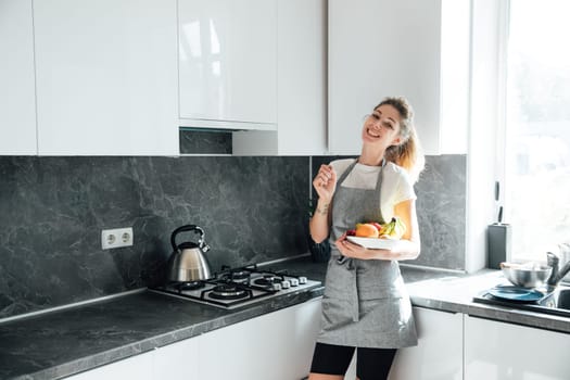 Woman housewife smiling with fruit basket in kitchen