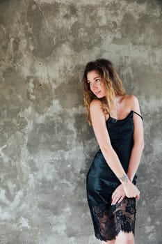 Fashionable woman in summer black silk dress looking away