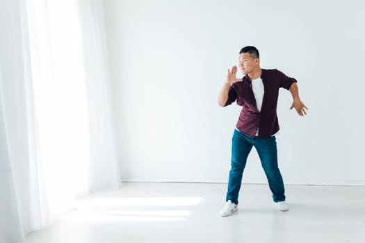 Asian man dancing to music alone in room