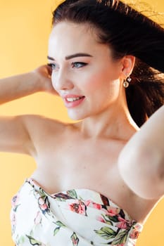 Portrait of a beautiful gentle brunette woman in a dress with flowers