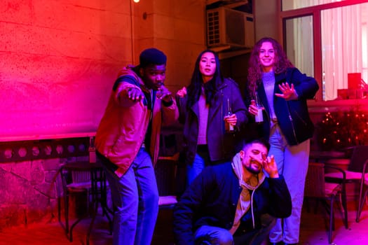 A group of four friends gathers at a lively venue, celebrating with drinks and enjoying the colorful atmosphere. They dance and laugh, embracing the joyful night energy around them.