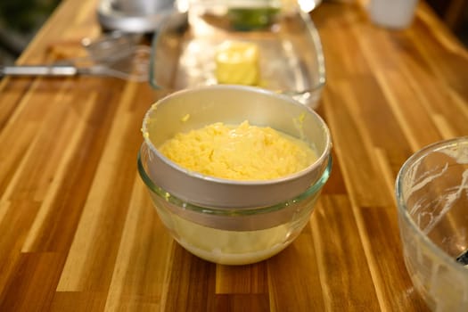 Close up of butter and buttermilk separation on wooden countertop.