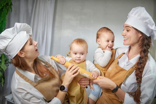 A families enjoys a fun cooking session, playfully covered in flour while engaging with little ones in warm kitchen. Mothers and children having fun