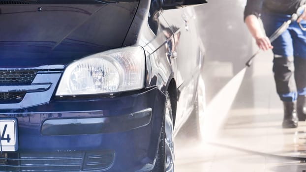 A close-up of a car headlight during a car wash